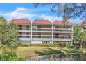 Two-story condo building with balconies, red tile roofs, and waterfront view at 3801 E Bay Dr # 209, Holmes Beach, FL 34217