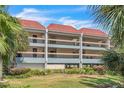 Two-story condo building with balconies and red tile roofs at 3801 E Bay Dr # 209, Holmes Beach, FL 34217