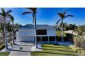 Contemporary waterfront home with palm trees and circular driveway at 501 Outrigger Ln, Longboat Key, FL 34228