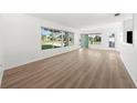 Bright and airy living room with light wood flooring and large windows at 6116 Rodgers Ave, Sarasota, FL 34231