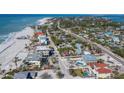 Beautiful aerial view of a home with a pool, near the beach, and surrounded by tropical greenery at 6473 Gulf Of Mexico Dr, Longboat Key, FL 34228