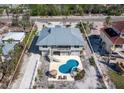 Aerial view of the backyard with a uniquely shaped pool, patio furniture, and well-maintained landscaping at 6473 Gulf Of Mexico Dr, Longboat Key, FL 34228