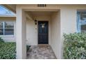 Home's entrance with black door and brick walkway at 6884 W Country Club Ln, Sarasota, FL 34243