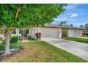 Exterior of a house with a tree and well-kept lawn at 7317 Ballantrae Pl # 27B, Sarasota, FL 34238