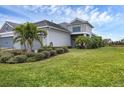 House with gray siding, lush landscaping, and a two-car garage at 2616 Sapphire Blue Ln, Bradenton, FL 34211