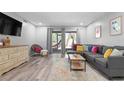 Bright living room with gray sectional and wood-look floors at 2744 Hidden Lake Blvd # A, Sarasota, FL 34237