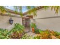 Inviting entryway with an ornate iron gate and lush landscaping at 3484 Hadfield Greene # 22, Sarasota, FL 34235