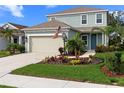 Two-story house with light green siding, beige garage door, and landscaped yard at 3543 Woodmont Dr, Parrish, FL 34219