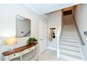 Bright entryway with a console table, mirror, and staircase leading upstairs at 5560 Cannes Cir # 3-106, Sarasota, FL 34231