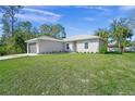 Newly built house showcasing a gray exterior and spacious lawn at 5629 Crenshaw Ln, North Port, FL 34286