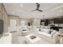 Modern living room with open kitchen, staged furniture, and ceiling fan at 5629 Crenshaw Ln, North Port, FL 34286
