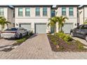 Front view of townhouses with grey garages and paved driveways at 6404 Silverstar Dr, Sarasota, FL 34240