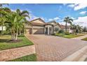 Landscaped property featuring a brick driveway and palm trees at 7014 Whittlebury Trl, Lakewood Ranch, FL 34202