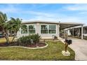 Single-wide manufactured home with landscaped yard and carport at 716 Blackburn Blvd, North Port, FL 34287
