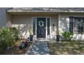 Front door entrance with wreath, planters, and walkway at 8006 Oak Dr, Palmetto, FL 34221