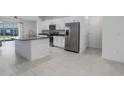 Modern kitchen with stainless steel appliances, an island, and white cabinets at 8684 Canyon Creek Trl, Parrish, FL 34219