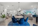 Open concept kitchen and dining area with modern appliances and blue chairs at 11628 Middle Fork Way, Parrish, FL 34219