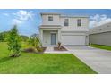 Two-story house, white siding, gray accents, and a two-car garage at 13009 Cedar Elm Lane, Parrish, FL 34219