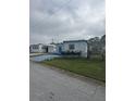 White manufactured home with blue accents and a small, grassy yard at 1660 Old Elm St, Sarasota, FL 34234