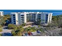 An aerial view of a waterfront condo building with parking and lush landscaping at 2110 Harbourside Dr # 522, Longboat Key, FL 34228