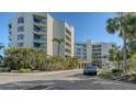 Condo building with palm trees and a paved driveway at 2110 Harbourside Dr # 522, Longboat Key, FL 34228