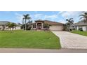 One-story house with a paved driveway and lush green lawn at 25067 Palisade Rd, Punta Gorda, FL 33983