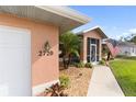 House entrance with walkway, screened porch, and American flag at 2720 S Biscayne Dr, North Port, FL 34287