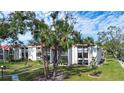 Condo building with lush landscaping and palm trees in a sunny location at 3259 Beneva Rd # 102, Sarasota, FL 34232