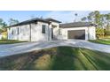 Contemporary home with gray paver driveway and lush lawn at 3782 Horace Ave, North Port, FL 34286