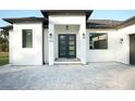 Modern front entrance with black double doors and gray paver walkway at 3782 Horace Ave, North Port, FL 34286