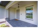 Front entry with paver porch and gray door at 4892 Hillman Ter, North Port, FL 34288