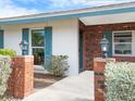 Brick entryway with teal shutters, lamp posts, and lush landscaping at 548 Ketch Ln, Longboat Key, FL 34228