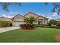 One-story house with tile roof, two-car garage, and lush landscaping at 6726 Virginia Xing, University Park, FL 34201