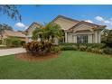 One-story house with tile roof, attached garage, and tropical landscaping at 6726 Virginia Xing, University Park, FL 34201