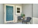 Teal front door with welcome mat and charming seating area at 8533 Lunar Skye St, Sarasota, FL 34241