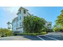 White building with palm trees and lush landscaping in a waterfront community at 888 S Orange Ave # 3D, Sarasota, FL 34236