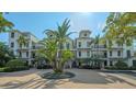 Exterior of a three-story building with palm trees and a courtyard at 888 S Orange Ave # 3D, Sarasota, FL 34236
