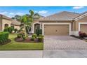 Two-story home with tan exterior, two-car garage, and well-manicured lawn at 12199 Sebring Ln, Venice, FL 34293