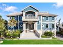 Grand waterfront home with elegant stone and blue exterior at 144 N Casey Key Rd, Osprey, FL 34229