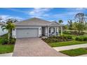One-story house with gray garage door and covered porch, nicely landscaped at 25042 Coquina Ridge Way, Englewood, FL 34223