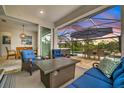 Relaxing screened-in patio with pool, spa, and outdoor seating at 25042 Coquina Ridge Way, Englewood, FL 34223