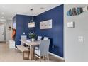 Dining area with a rustic table and blue accent wall at 3206 Hilltop Cir, Bradenton, FL 34211