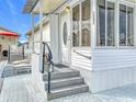 Inviting front exterior of a mobile home featuring steps, patio furniture, and landscaping at 3333 26Th E Ave # 1241, Bradenton, FL 34208