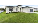 House with gray garage door and lush green lawn at 3425 Dryden St, North Port, FL 34288