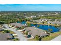 Scenic aerial view of homes nestled by a tranquil pond surrounded by lush greenery at 3663 Muirfield Dr # 4B, Sarasota, FL 34238