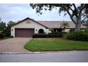 Single-story house with brown garage door and neat landscaping at 3947 Country View Dr, Sarasota, FL 34233