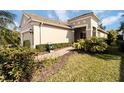 Tan house with walkway, landscaping, and a two-car garage at 5050 Maymont Park, Bradenton, FL 34203