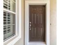 Dark brown front door with a white frame and adjacent window at 5050 Maymont Park, Bradenton, FL 34203