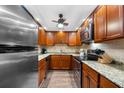 Well-equipped kitchen with wood cabinets, granite counters, and stainless steel appliances at 5855 Midnight Pass Rd # 311, Sarasota, FL 34242