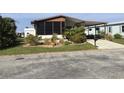 Front view of a manufactured home with mature landscaping at 763 Lakeside Dr, North Port, FL 34287